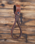 Brown leather truck grab-strap with stitching detail on a wooden background