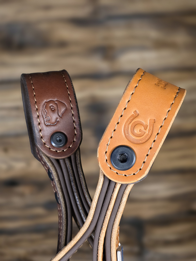 Closeup of two Giddyupz handles with Giddyupz logo and Hellhound logo displayed against a blurred wooden background