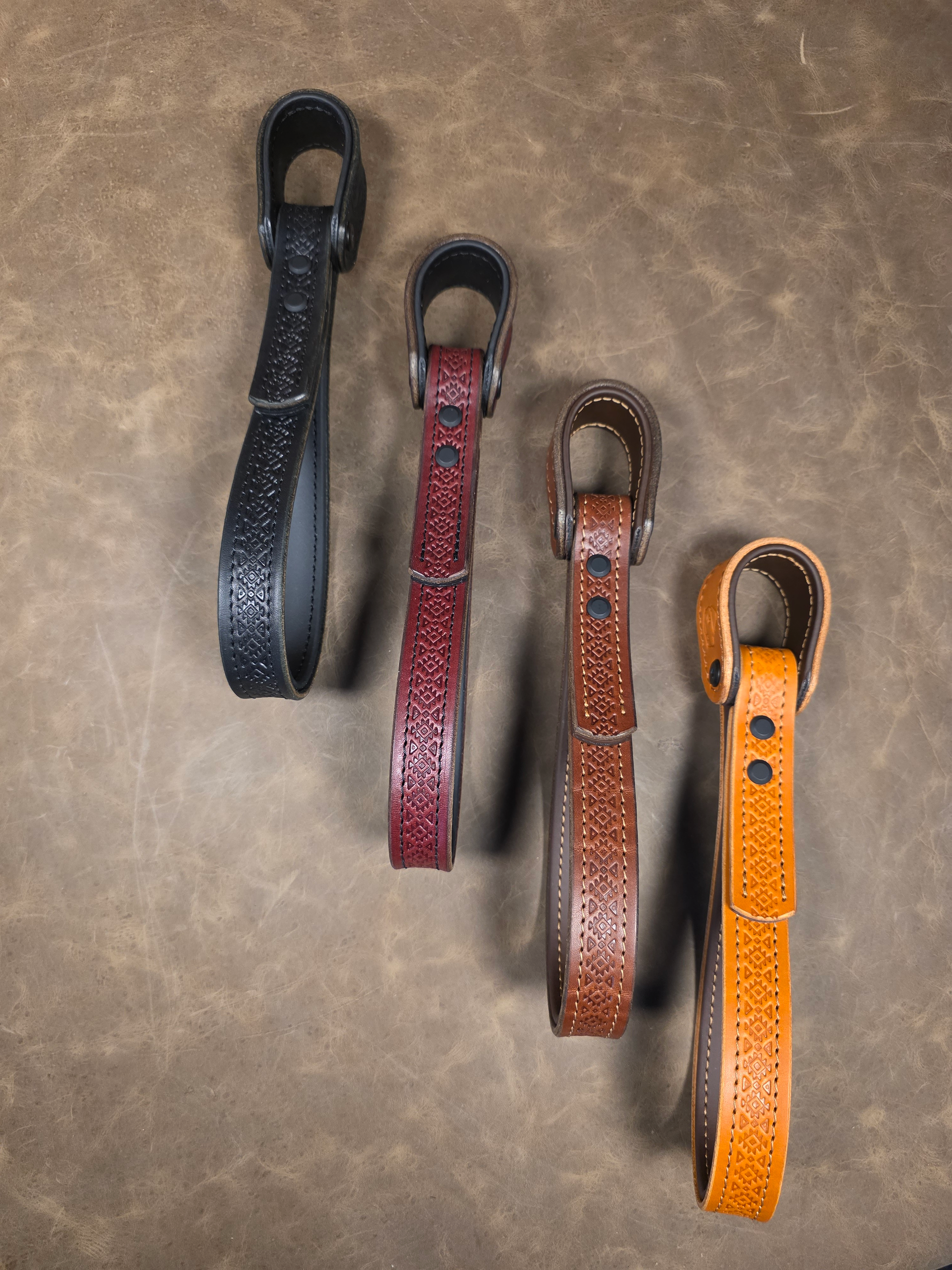 Santa Fe patterned Giddyupz grab handles in four colors on a leather surface