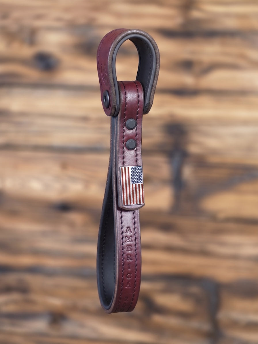 Oxblood leather Giddyupz Handle with American flag emblem on a wooden background